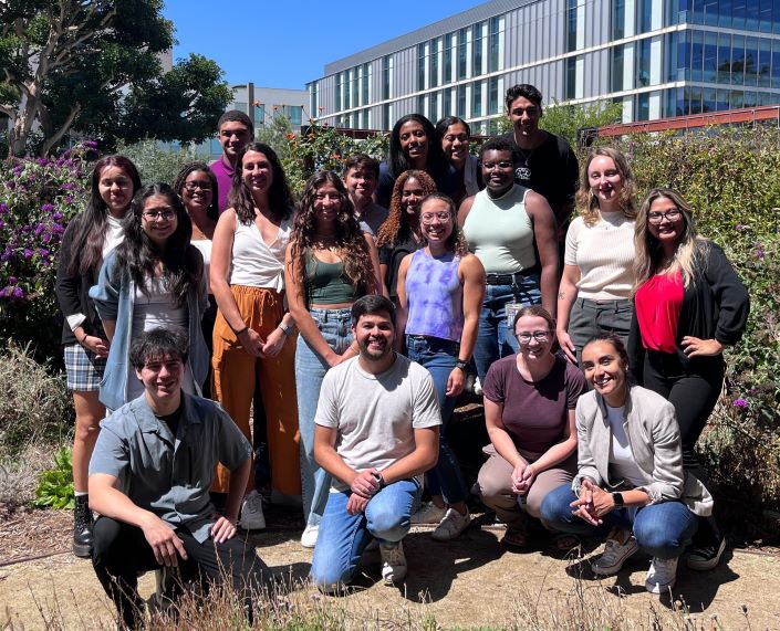 A large group of diverse students posing with their program leadership for a photo