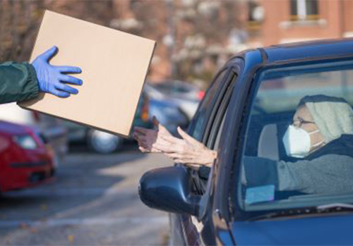 a box being handed to person in car